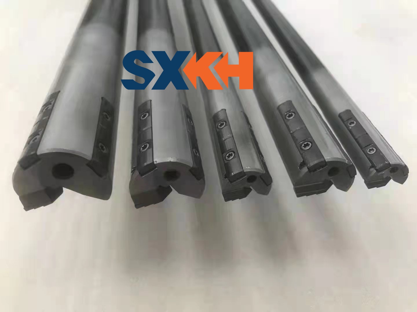 A collection of deep hole drilling tools, including drill bits and guides, for industrial drilling machines.