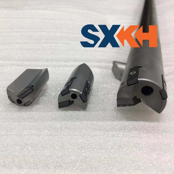 A collection of deep hole drilling tools, including drill bits and guides, for industrial drilling machines.