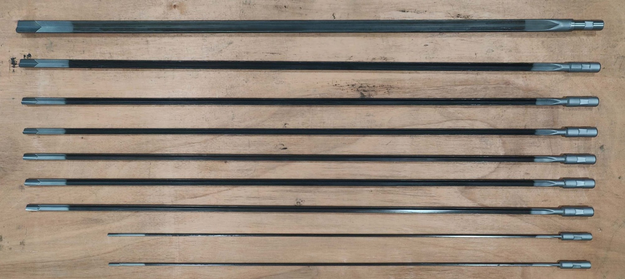 A collection of deep hole drilling tools, including drill bits and guides, for industrial drilling machines.