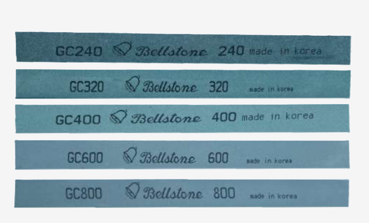 Fine-grit polishing stones used for removing EDM recast layers and final surface preparation.